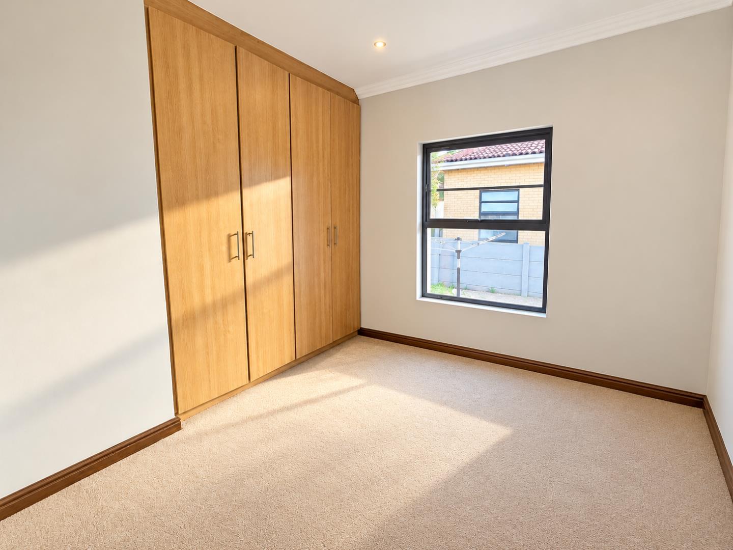 769601_Bright_Empty_Bedroom_with_Oak_Wardrobe_and_Window.png